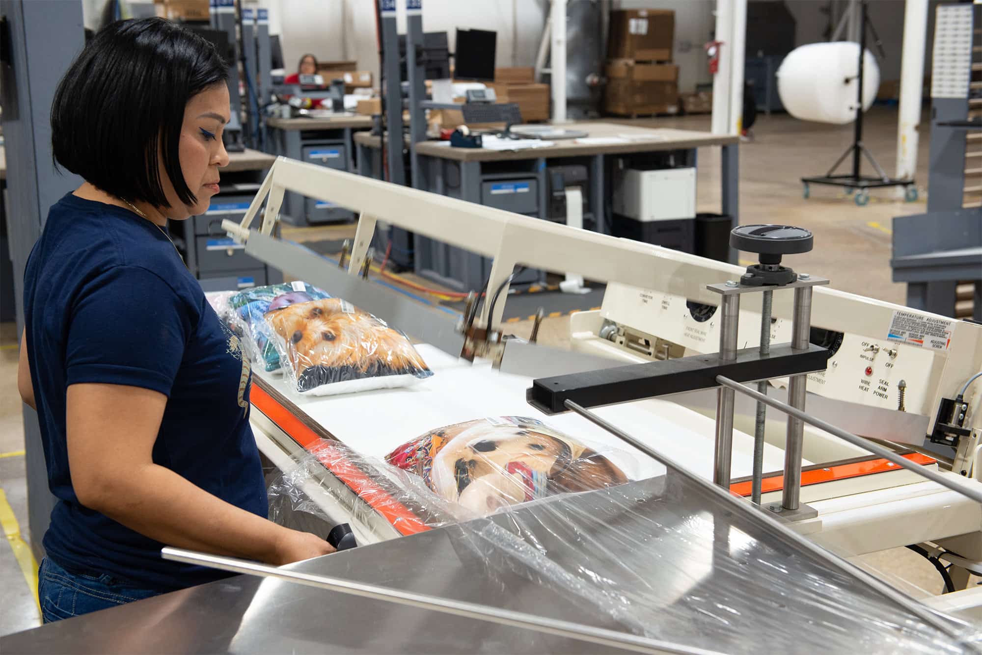 a worker shrink wraps custom printed pillows